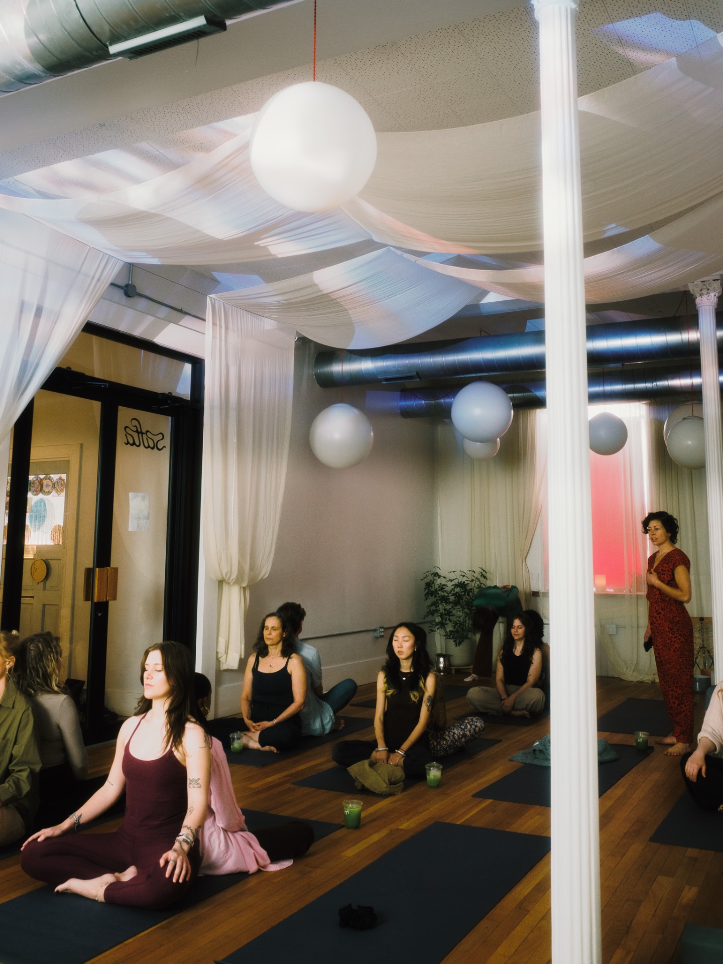 Meditation circle beneath draped fabric and hanging globes at Safta