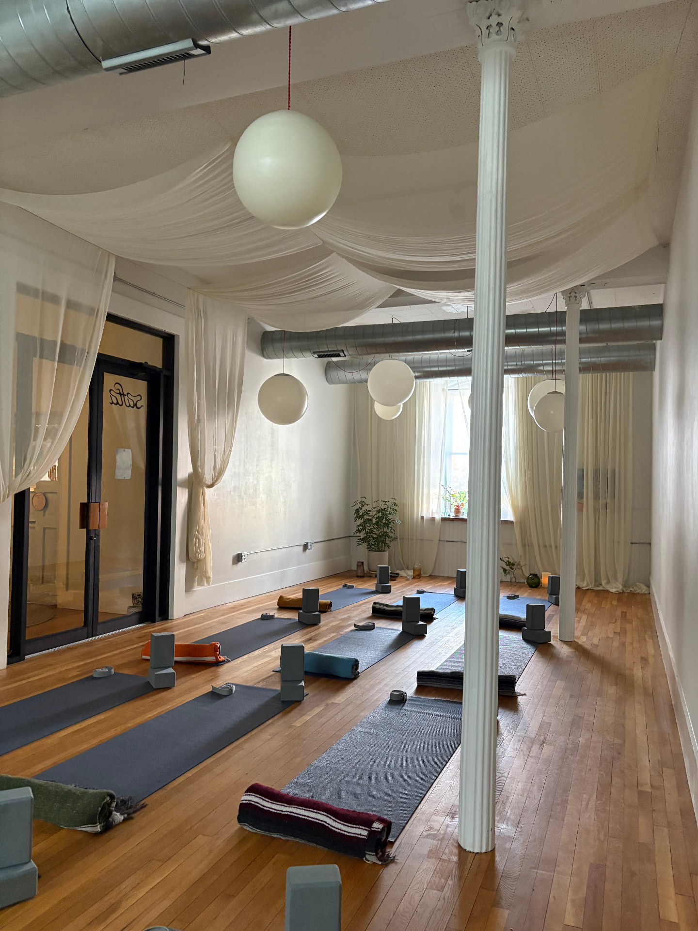 The Safta studio with mats, blocks, and soft draped fabric